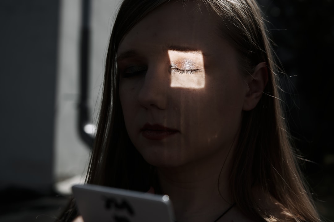 a woman with her eyes closed looking at a tablet