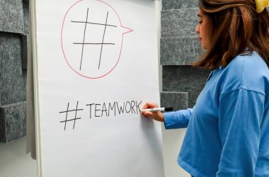 a woman writing on a white board with a marker