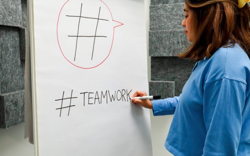 a woman writing on a white board with a marker