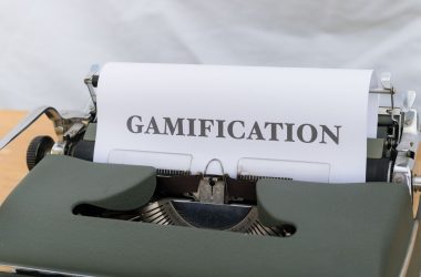 a close up of a typewriter with a paper that reads gamification