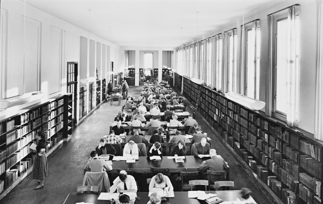 a black and white photo of people in a library