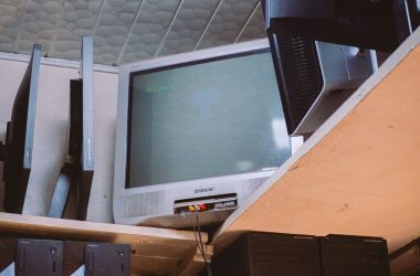A room with two televisions and a keyboard