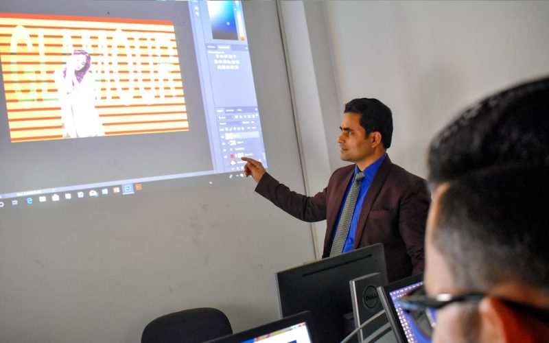 a man standing in front of a projector screen giving a presentation