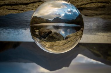 clear glass ball on white sand during daytime