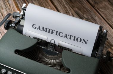 a close up of a typewriter with a paper that reads gamification