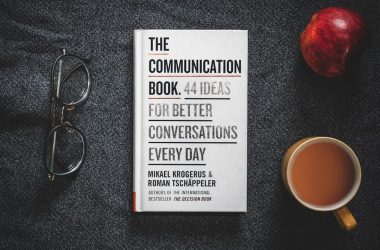 a book sitting on top of a table next to a cup of coffee