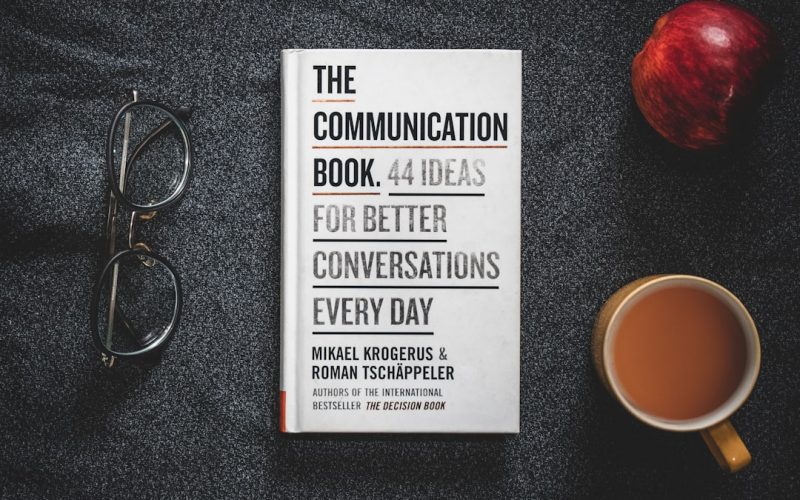 a book sitting on top of a table next to a cup of coffee