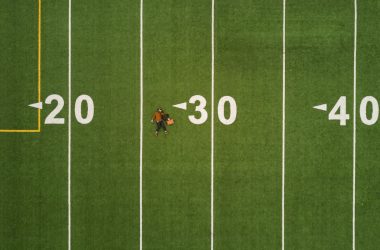 man lying on 30 yards on football field