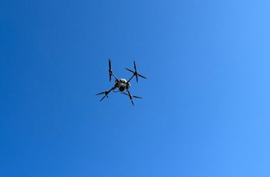 a small airplane flying through a blue sky