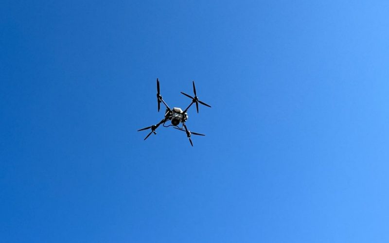 a small airplane flying through a blue sky