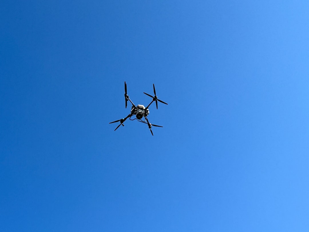a small airplane flying through a blue sky