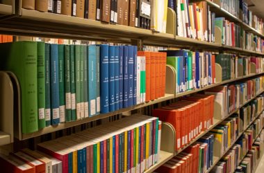 Bookshelves are filled with colorful books in a library.