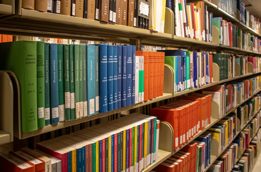 Bookshelves are filled with colorful books in a library.
