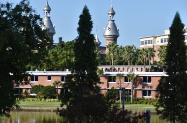 white and brown concrete building near green trees during daytime
