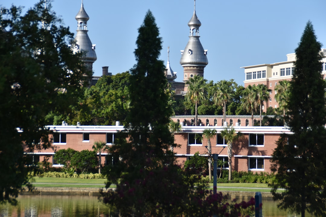 white and brown concrete building near green trees during daytime
