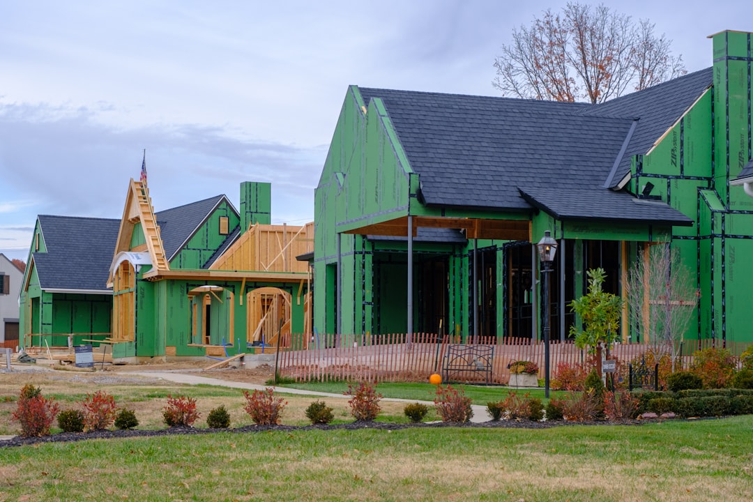 A row of green houses with a clock tower in the background