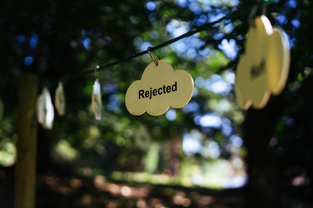 Signs reading "rejected" hang on a line.