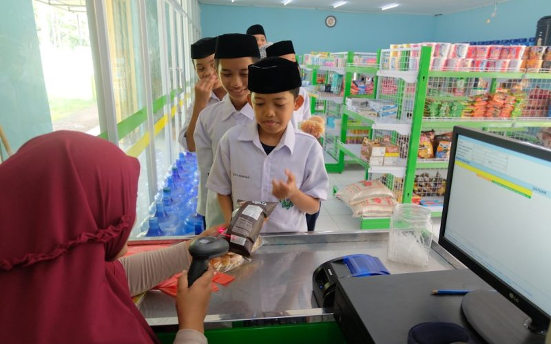 a woman is handing something to a boy in a store