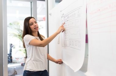 woman standing pointing paper on board