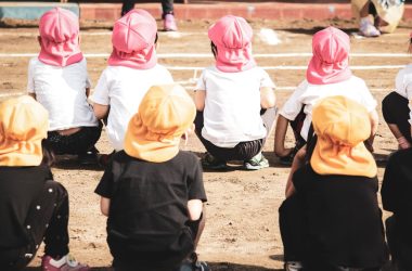 children in black shirt and pink hijab standing on brown sand during daytime