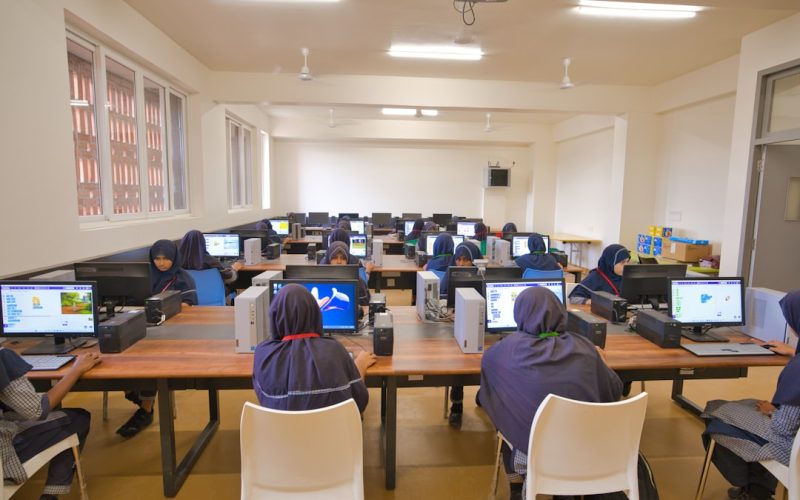 A group of people sitting at desk with laptops