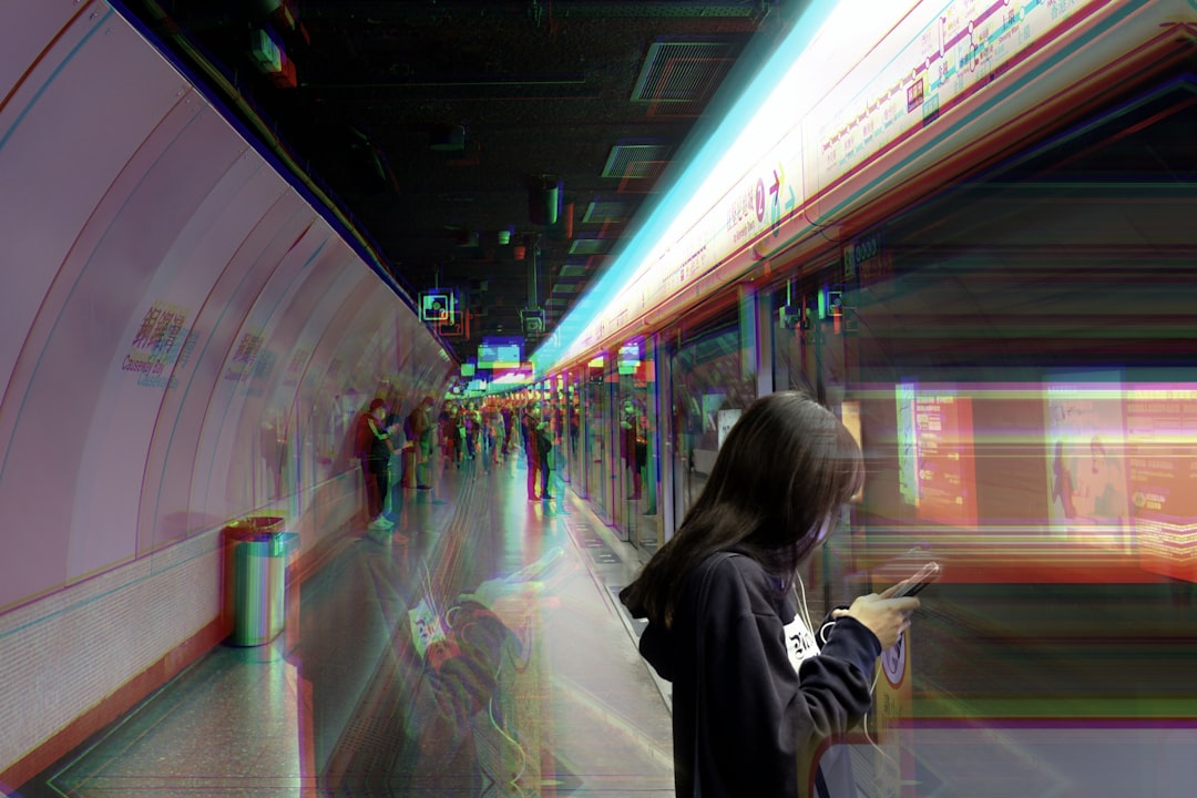woman in gray hoodie standing in front of train