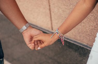 a close up of two people holding hands