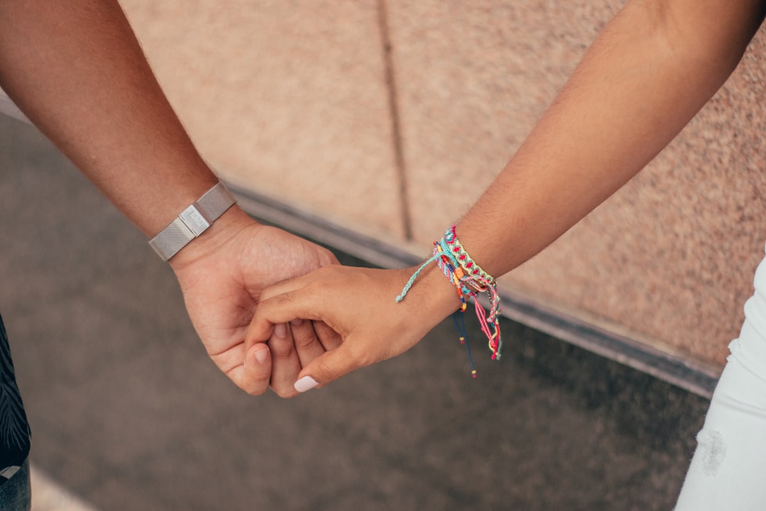 a close up of two people holding hands