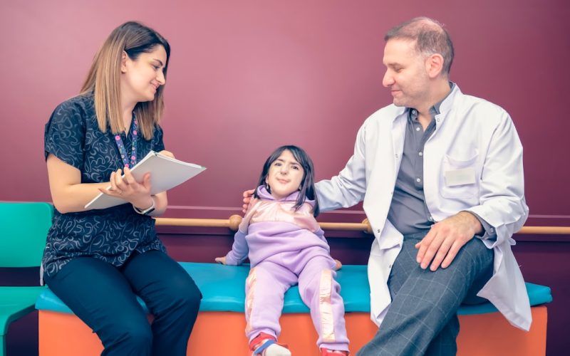a woman and a man sitting on a bench with a little girl