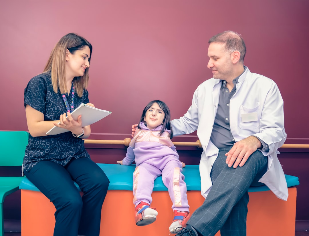 a woman and a man sitting on a bench with a little girl