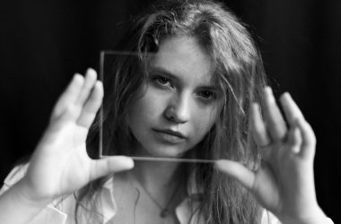 grayscale photo of woman holding her hair