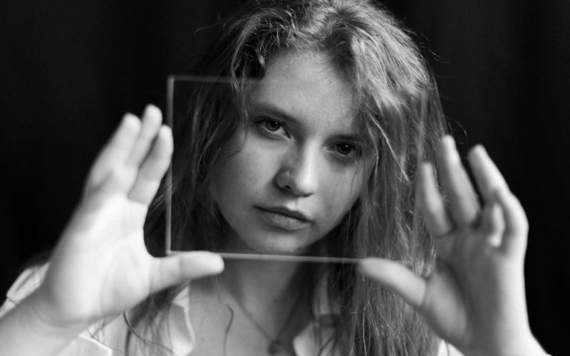 grayscale photo of woman holding her hair