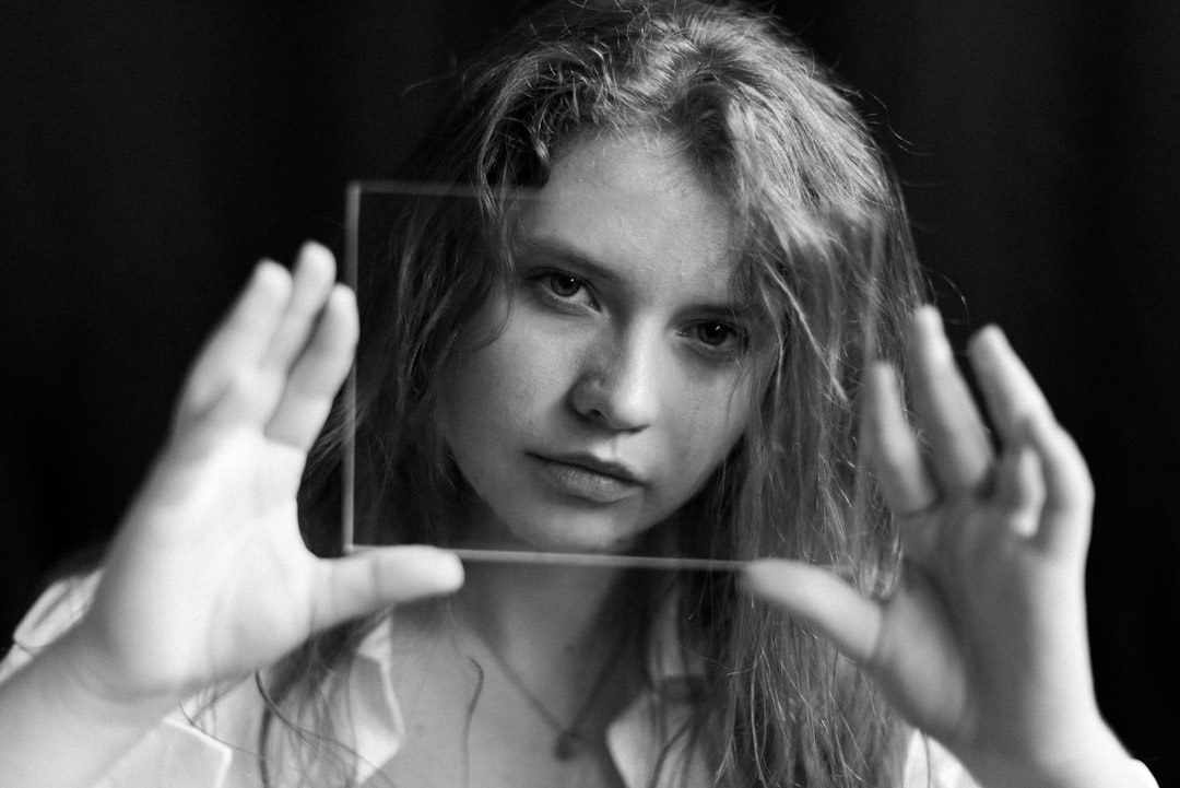 grayscale photo of woman holding her hair