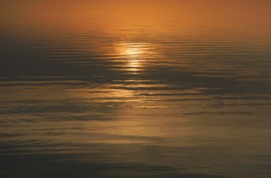 reflection of sun on body of water