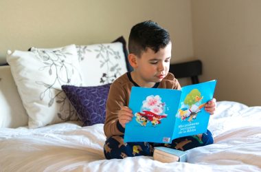 boy in blue and white crew neck t-shirt reading book