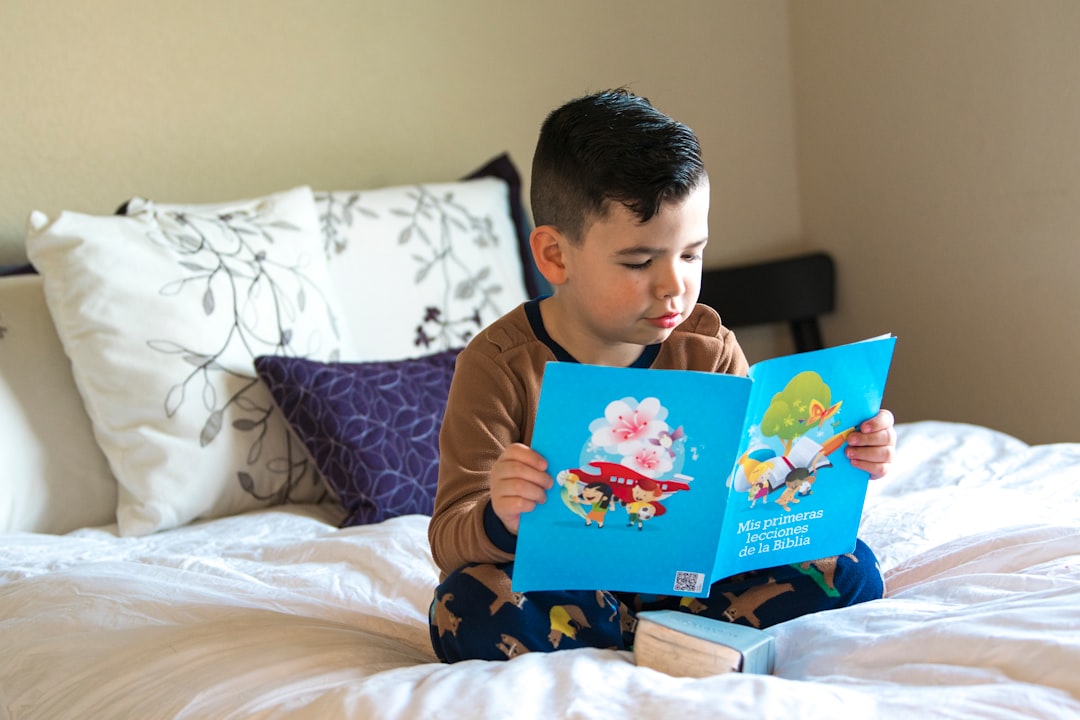 boy in blue and white crew neck t-shirt reading book