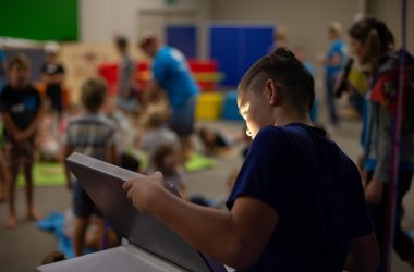 boy in black t-shirt holding tablet computer