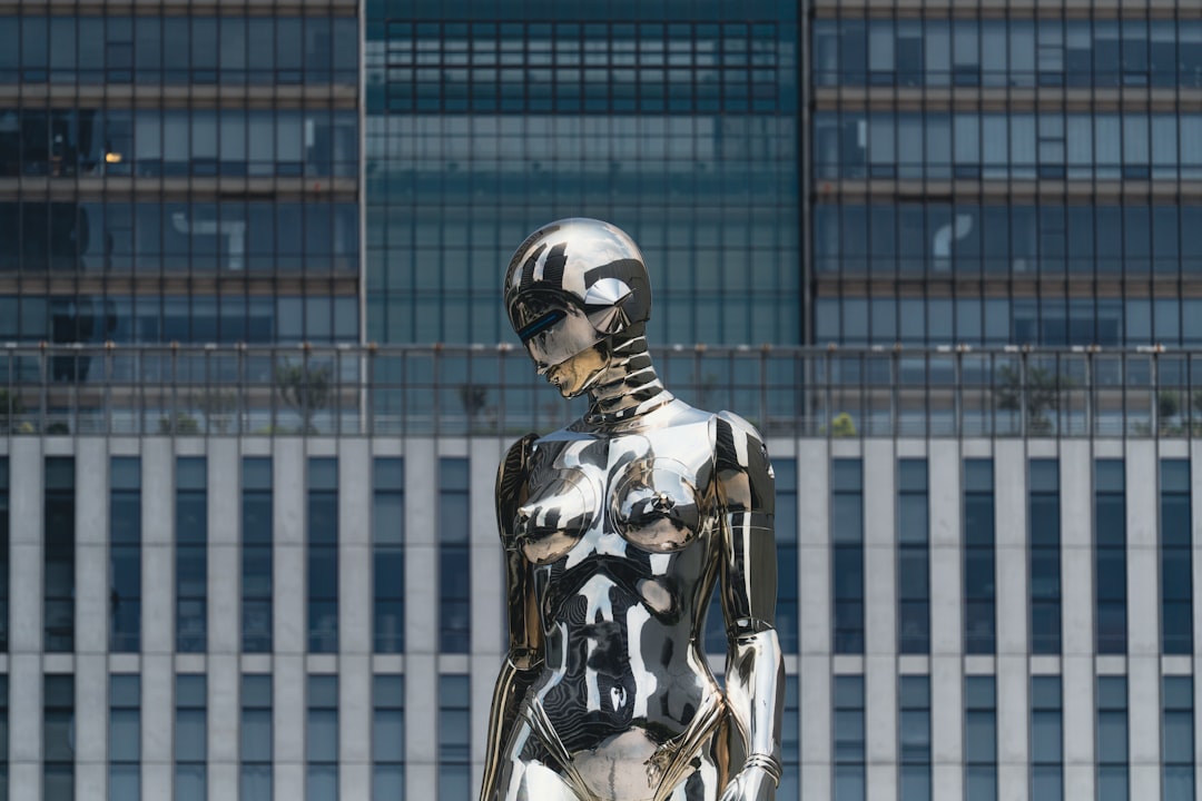 A metallic sculpture stands before a building.