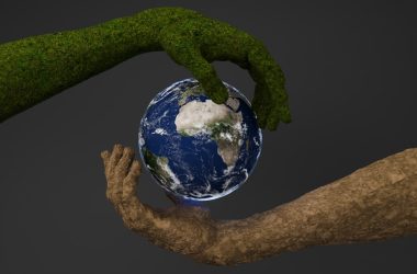 Two hands are holding a small earth globe