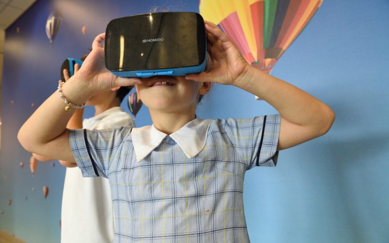 boys using blue and black virtual reality headset