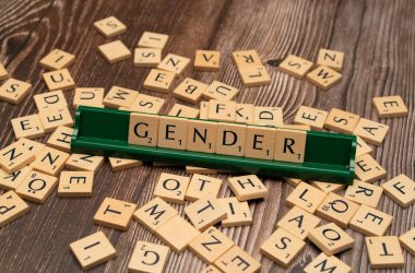 scrabble tiles spelling out the word gender on a wooden table