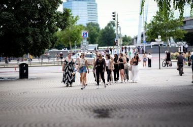 A group of people walk on a paved road.