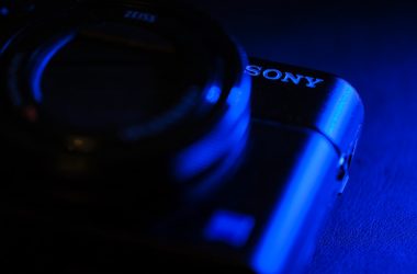 black sony camera lens on blue surface