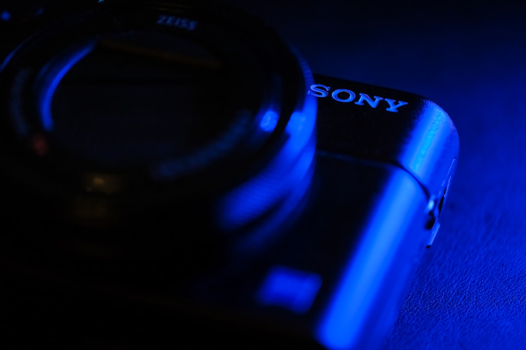 black sony camera lens on blue surface