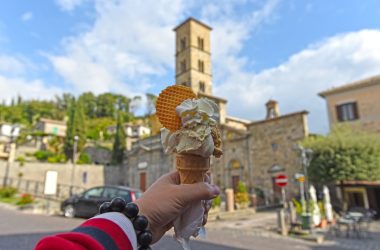 a hand holding a waffle cone with a waffle on top of it