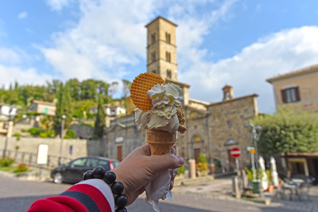 a hand holding a waffle cone with a waffle on top of it