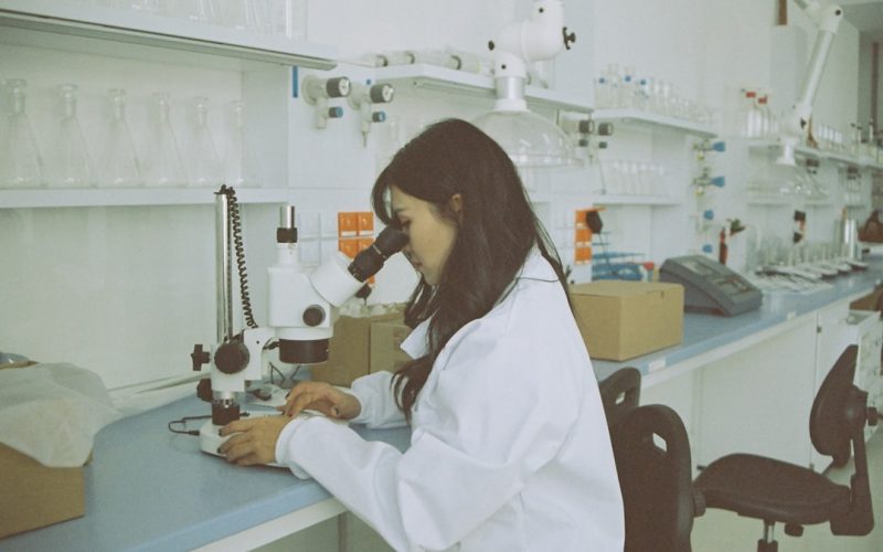woman in white long sleeve shirt using white and black sewing machine