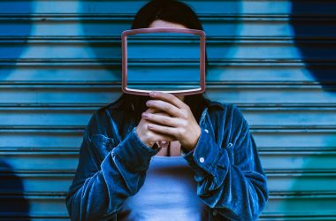 man covering face with mirror