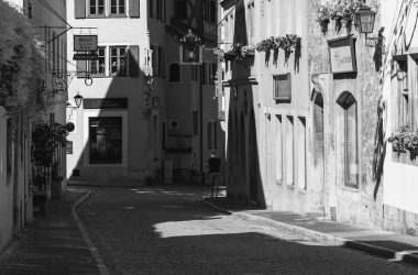 A black and white photo of a narrow street