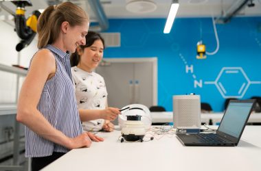 woman in white and black polka dot shirt holding white headphones